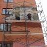 На улице Дагестанской восстанавливают облицовку фасада жилого дома